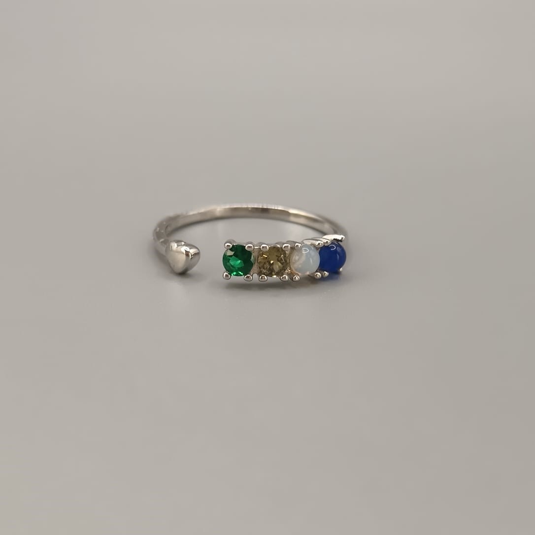 Anillo abierto con cuatro circonitas en un extremo y un corazón liso en el otro.