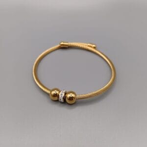 Brazalete ajustable rigido dorados de larga durabilidad con  dos bolas y en medio de esta un aro con circonitas
