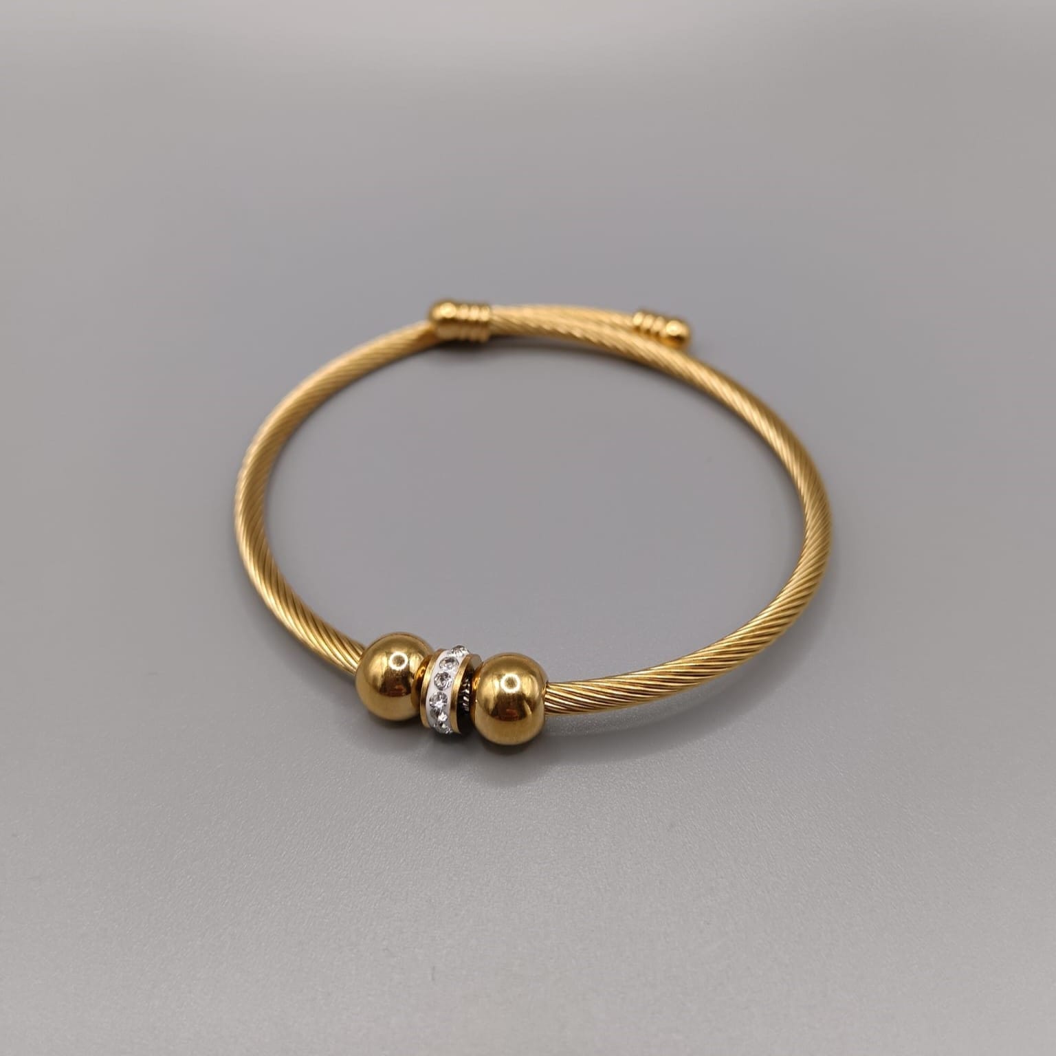 Brazalete ajustable rigido dorados de larga durabilidad con dos bolas y en medio de esta un aro con circonitas