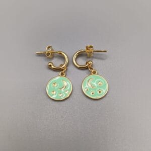 Pendientes en plata de ley, aros montados con palillo y cierre presion cuelga de ellos un colgante con estrella y luna en relieve sobre esmaltado en color verde agua