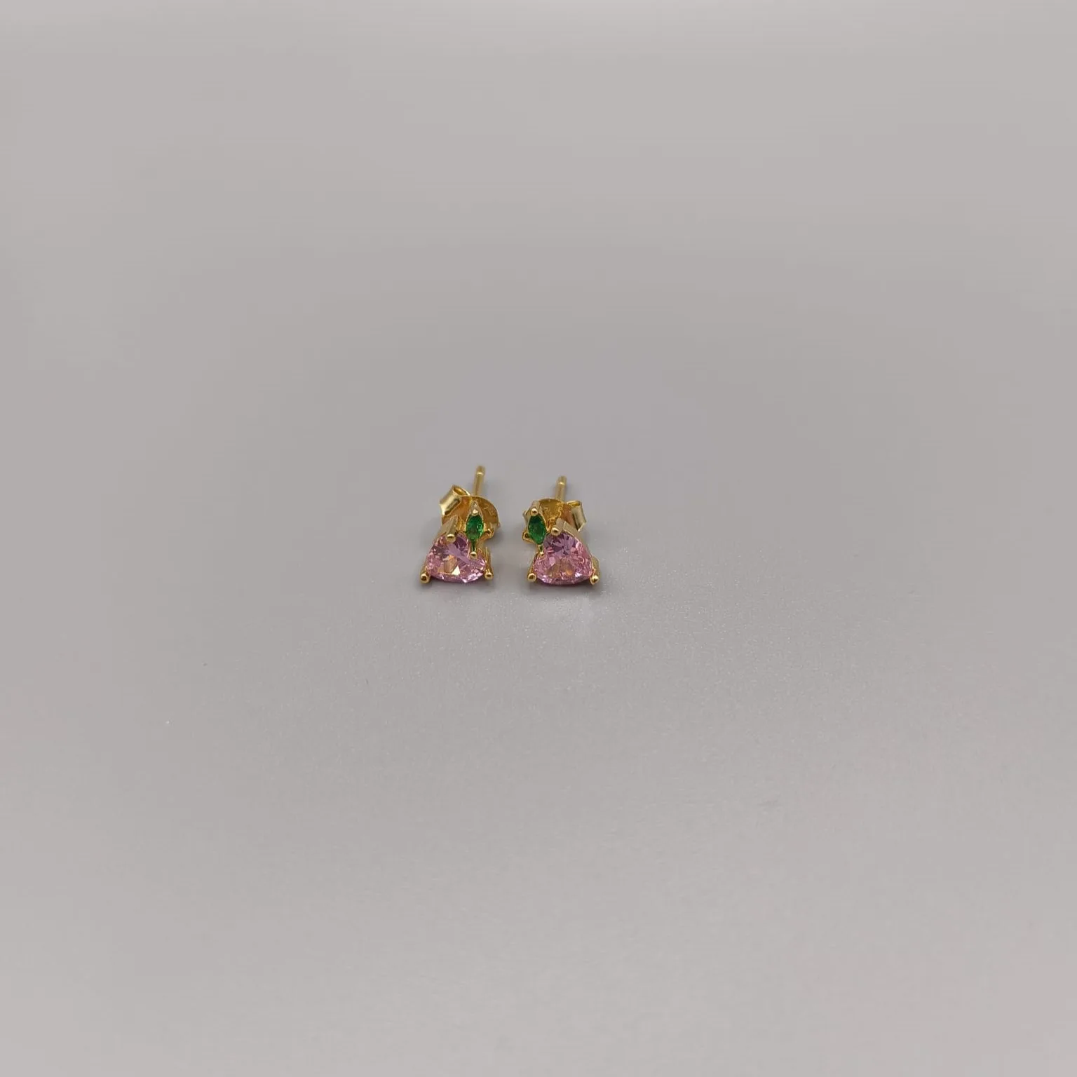 Pendientes en plata de ley montados con dos circonitas en forma de corazon color rosa y en forma de hoja color verde esmeralda